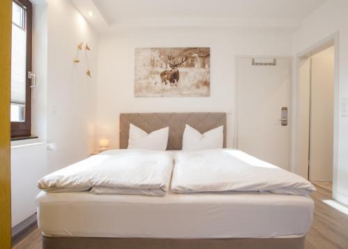 a white bedroom with a large white bed in it at Zum Hohlen Rain in Winterberg
