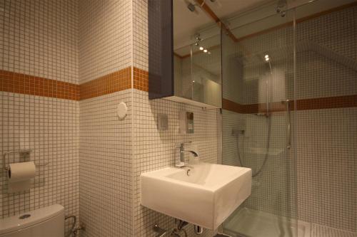 a bathroom with a sink and a shower and a toilet at Hotel Rhodos Morzine in Morzine