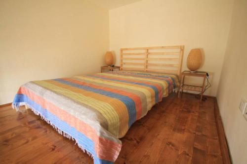 Un dormitorio con una cama con una manta a rayas. en Bilocale Fronte Mare, en Marina di Pisa