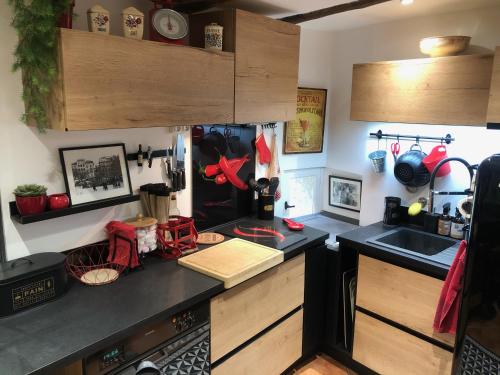 - une cuisine avec un plan de travail noir et un évier dans l'établissement Maison de village en Provence, à Baudinard