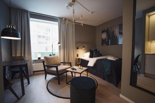 1 dormitorio con cama, escritorio y mesa en Sky Hotel Apartments, Hospitalstorget en Linköping