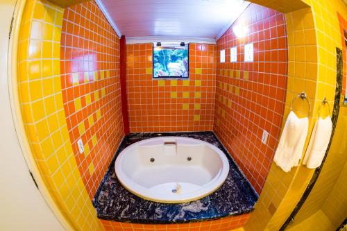a bathroom with a tub in the corner of a room at Pousada Suarez in Penedo