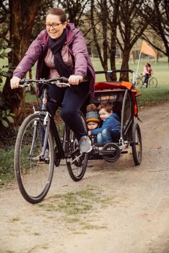 a woman riding a bike with a child in a cart at Glasson Lakehouse in Athlone