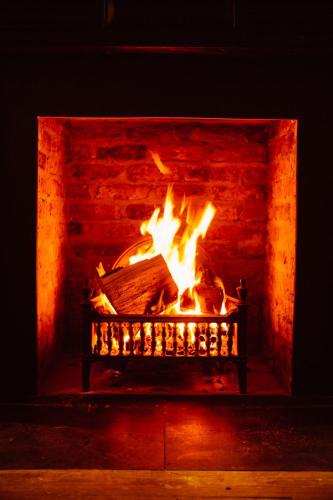 a fire in a brick fireplace with flames at Glasson Lakehouse in Athlone
