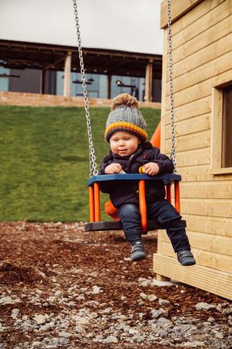 a baby sitting on a swing in a playground at Glasson Lakehouse in Athlone