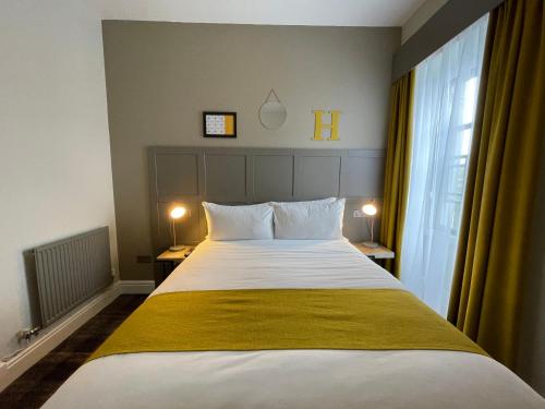 een slaapkamer met een groot bed en een raam bij The County Hotel in Haverfordwest