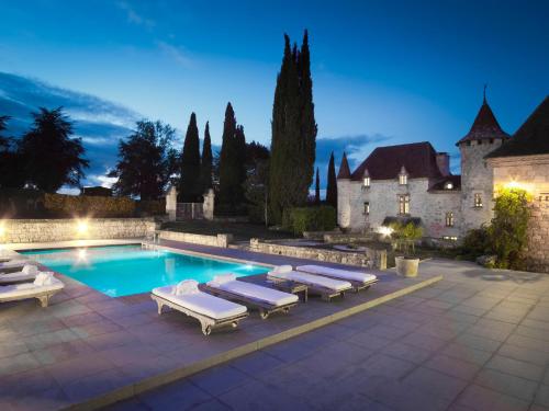 une piscine avec des chaises longues et une maison dans l'établissement Château La Colombie, à Saint-Caprais-de-Lerm