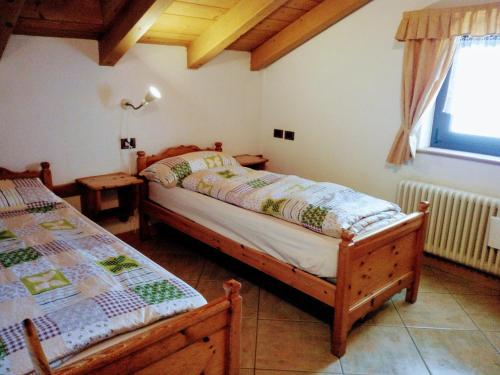 een slaapkamer met 2 aparte bedden en een raam bij Casa Rainolter in Livigno