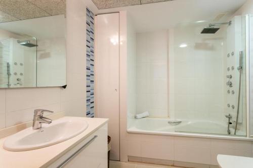 ein weißes Bad mit einem Waschbecken und einer Dusche in der Unterkunft ÁTICO PATACONA BEACH PLAYA in Valencia