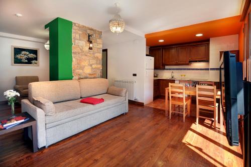 a living room with a couch and a kitchen at Villa de Plan Apartments&Suites in Plan