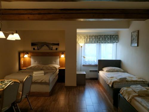 a bedroom with two beds and a table and a window at Podzamcze in Rożnów