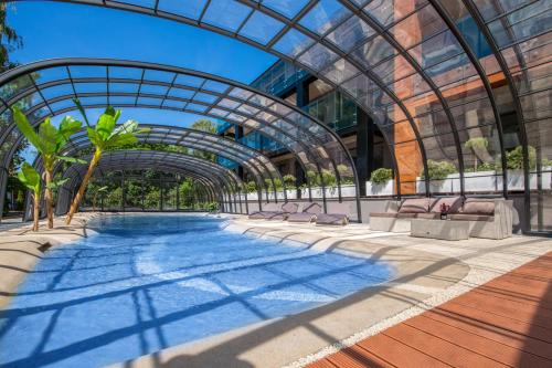 una piscina en un edificio con techo de cristal en Port 21 Pura Pool & Design Hotel - Adults Only en Krynica Morska