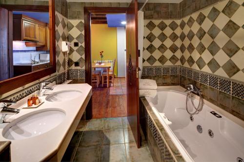 a bathroom with two sinks and a tub at Villa de Plan Apartments&Suites in Plan