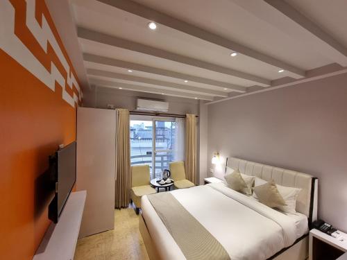 a hotel room with a bed and a television at Chautari Boutique Hotel in Pokhara