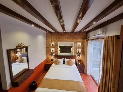 a bedroom with a large bed and a mirror at Chautari Boutique Hotel in Pokhara