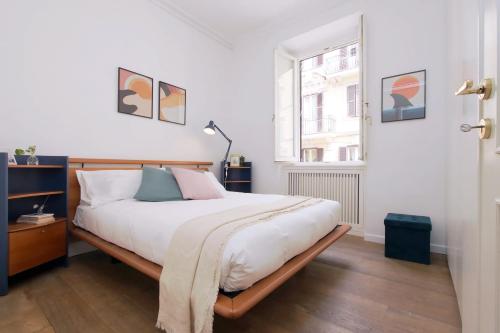 ローマにあるColosseo Terrace Apartmentのベッドルーム1室(白いシーツ付きのベッド1台、窓付)