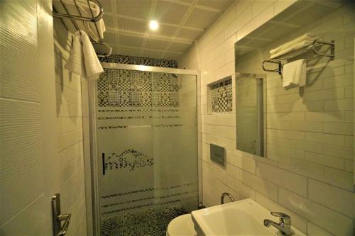 a bathroom with a shower and a sink at Milyos Hotel in Bucak