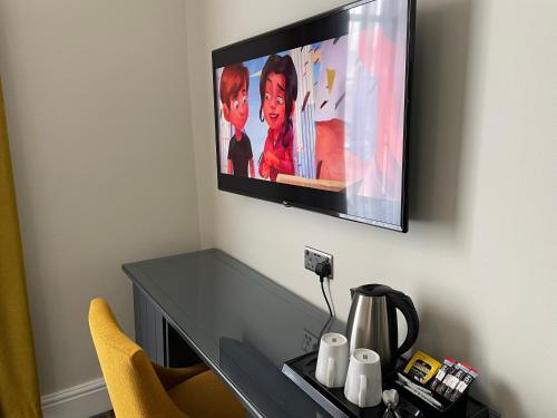 a television hanging on a wall above a desk at The County Hotel in Haverfordwest