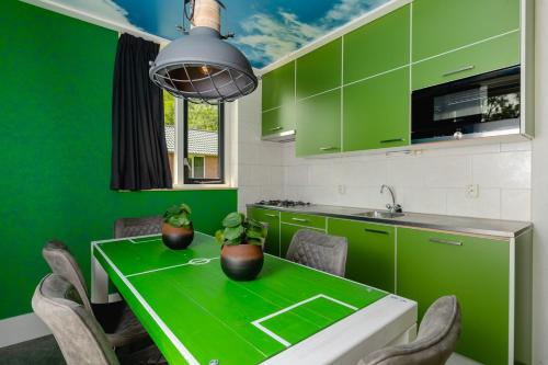 a green kitchen with a green table and chairs at Child Bungalow FC Mölke Stadium 6 People in Zuna