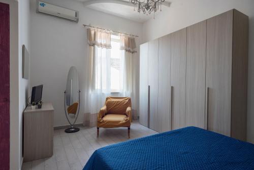ナポリにあるAppartamento Alexのベッドルーム1室(ベッド1台、椅子、鏡付)