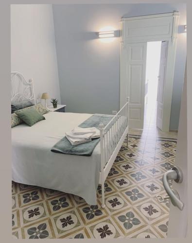 a bedroom with a white bed and a tile floor at B&B Puglia d'aMare in Lizzano