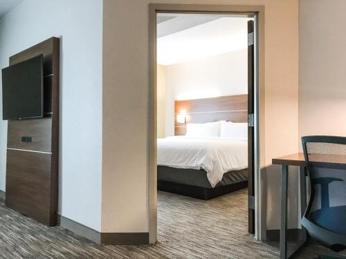 a hotel room with a bed and a mirror at Holiday Inn Express Statesboro by IHG in Statesboro