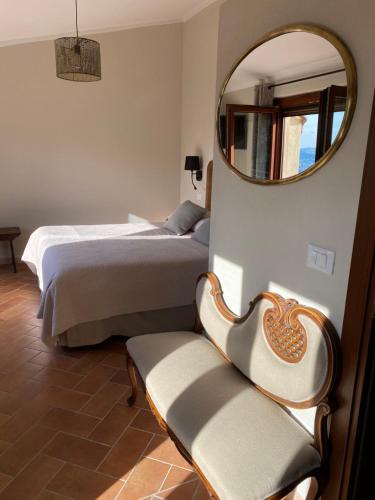 a hotel room with a bed, chair, and mirror at Vitabella Toscana in Seggiano