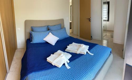 Una cama azul con toallas encima. en Villa Chaptalia, en Bandol