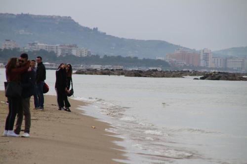 a group of people walking on the beach at B&B Pescara Centro Luxury Suite in Pescara