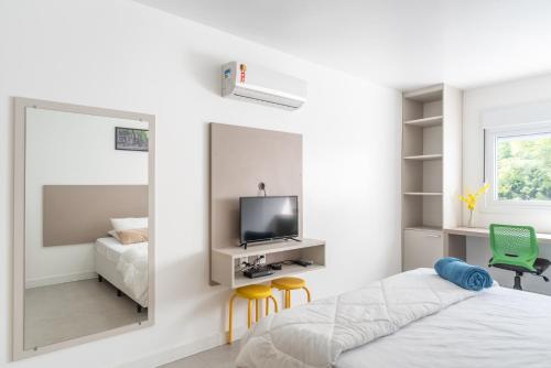 a bedroom with a mirror and a bed and a tv at Apartamento impecável Fernando Machado 828 in Porto Alegre