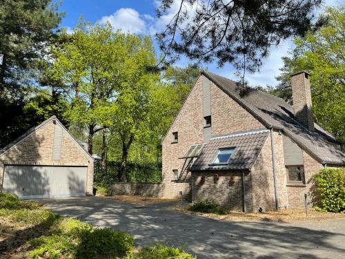 a brick house with a garage next to a driveway at Sterrenheide in Heusden - Zolder
