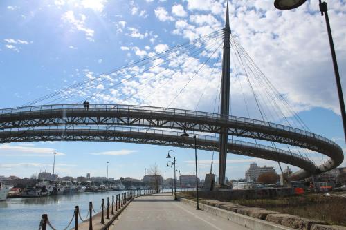a bridge over a river with a person walking on it at B&B Pescara Centro Luxury Suite in Pescara