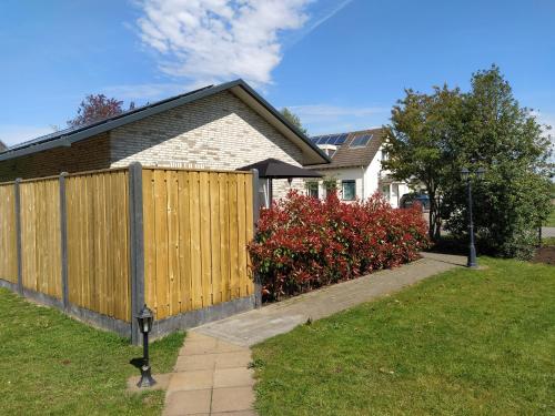 a wooden fence in front of a house at De Kuiperij in Arcen