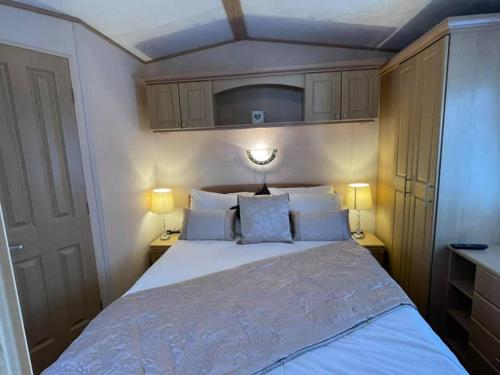 1 cama grande en una habitación pequeña con 2 lámparas en Mudeford Beach Lodge en Mudeford