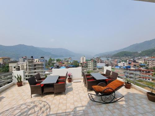 a patio with tables and chairs on a roof at Chautari Boutique Hotel in Pokhara