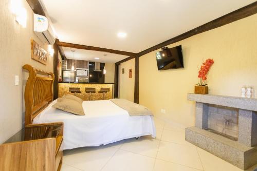 a bedroom with a bed and a fireplace at Pousada Cantagalo in Itaipava