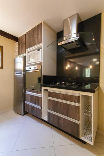 a kitchen with a stainless steel refrigerator and a stove at Pousada Cantagalo in Itaipava