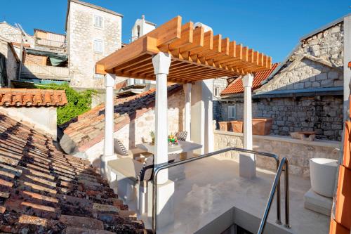 a patio with a wooden pergola on a roof at Villa Varda - Villa Latica in Hvar