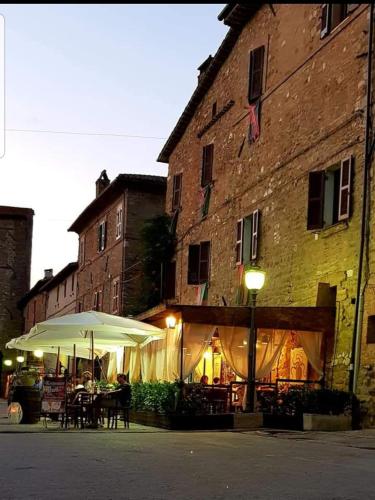 a building with a table and an umbrella next to a building at Residenza Porta Guelfa in Bevagna
