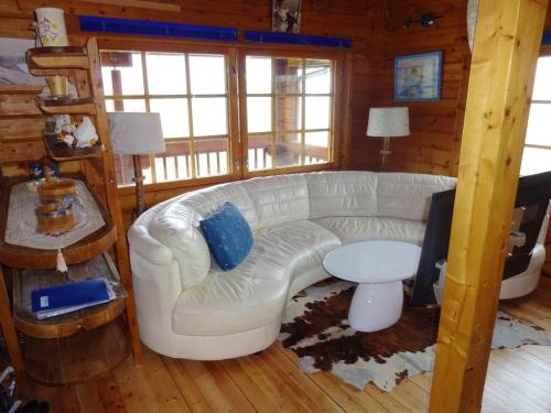 una sala de estar con un sofá blanco en una cabaña en Chalet de 3 chambres avec jardin amenage et wifi a Basse sur le Rupt, en Basse-sur-le-Rupt