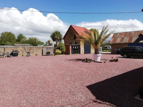 a gravel parking lot in front of a house at D'ici et d'ailleurs in Raids