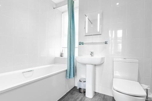 a white bathroom with a toilet and a sink at Brooklands Lodge in Bournemouth