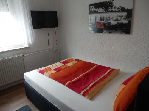 a bedroom with a bed with a colorful blanket on it at Gästezimmer Boxenstopp in Veitsbronn