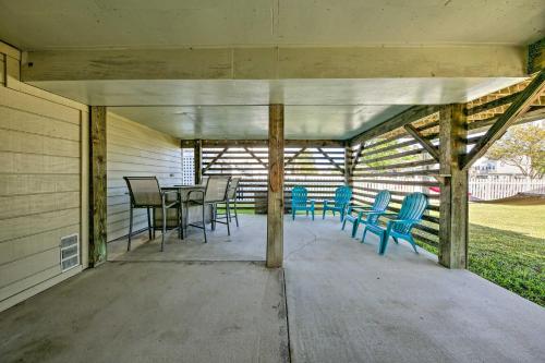 a covered patio with blue chairs and a table at Private Boat Dock Fall Escape in Outer Banks! in Kill Devil Hills