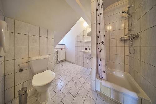 uma casa de banho com um WC, uma banheira e um lavatório. em Pension Říp em Pec pod Sněžkou