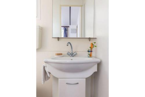 łazienka z białą umywalką i lustrem w obiekcie Comfort Lodge Principina w mieście Grosseto