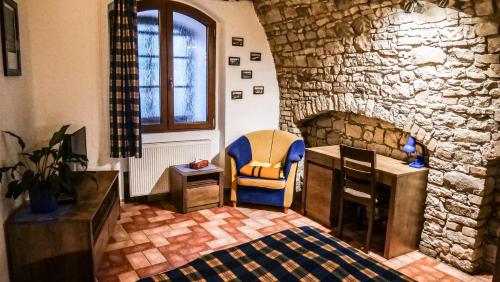 a room with a stone wall with a chair and a desk at Penzion Na Hradbách in Louny