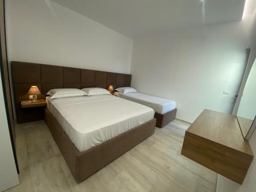 Habitación pequeña con 2 camas y espejo. en White Beach Villa 2 - Luxury, en Velipojë