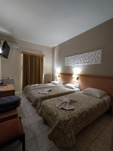 a hotel room with three beds with towels on them at Plaz Hotel in Selianitika