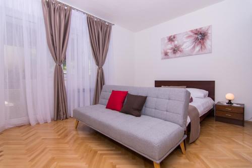 un soggiorno con divano e letto di Apartmani Mlačić a Okrug Donji